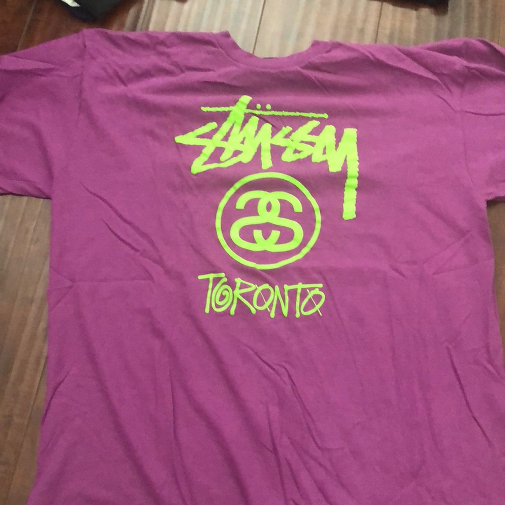 Purple and green lettering Stussy shirt .